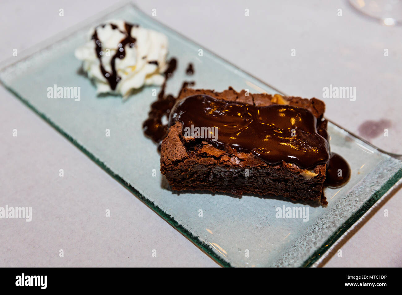 Brownie de chocolate y crema sirve sobre una placa de vidrio, restaurante El Tejar, Vilaflor, Islas Canarias, España Foto de stock