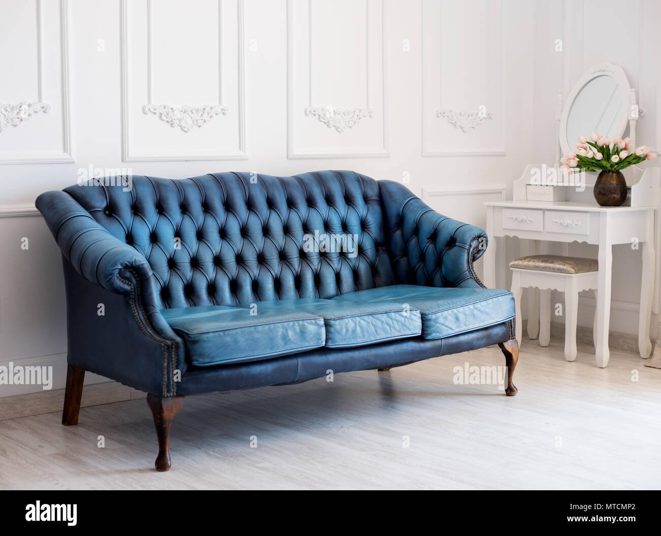 Lujoso cuero sofá azul estilo vintage en la habitación. Foto de stock