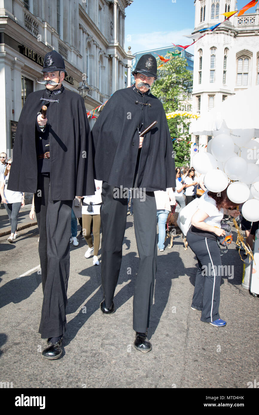Artistas Callejeros sobre pilotes en la época victoriana en uniforme de policía al inicio de la Caminata jurídico de Londres 2018 Foto de stock