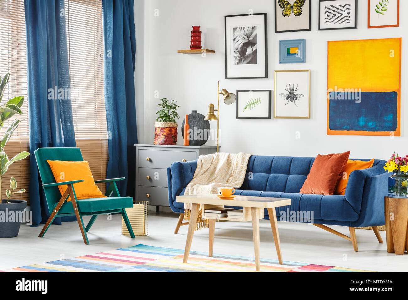 Foto real de un colorido salón interior con un sillón verde y un sofá de  color azul marino de pie en una mesa de café de madera Fotografía de stock  - Alamy