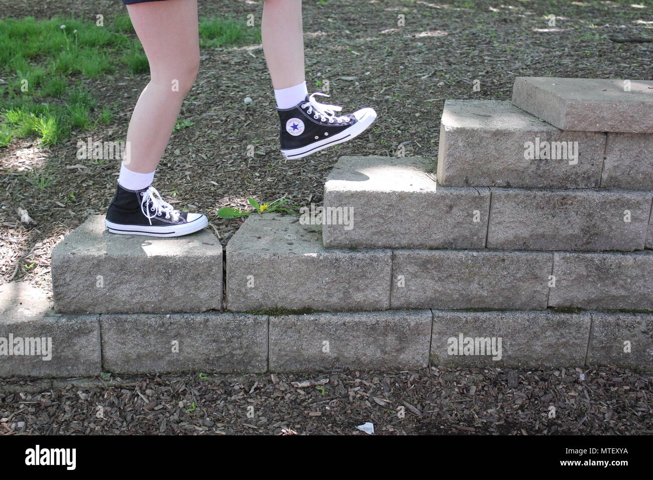 Chica adolescente de subir y bajar las escaleras vistiendo calcetines  blancos y un par de zapatillas converse negro alto-tops Fotografía de stock  - Alamy