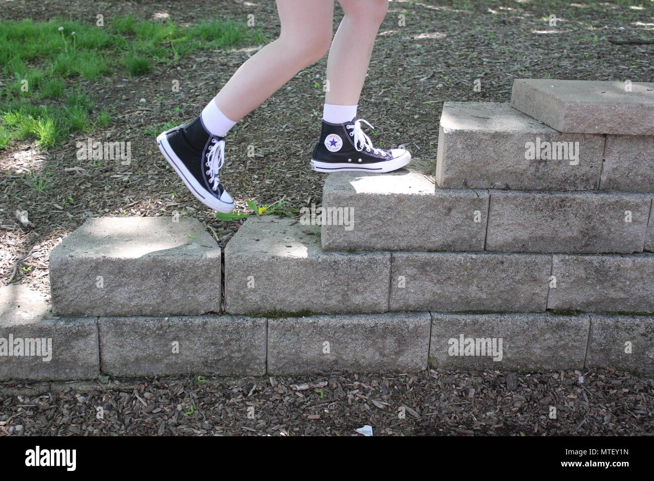 Chica adolescente de subir y bajar las escaleras vistiendo calcetines  blancos y un par de zapatillas converse negro alto-tops Fotografía de stock  - Alamy