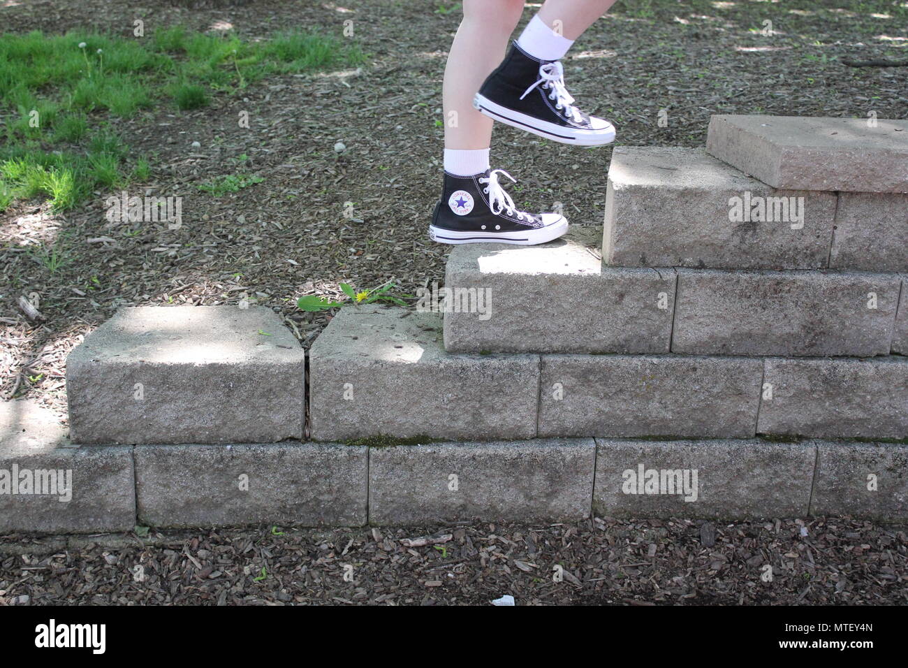 Chica adolescente de subir y bajar las escaleras vistiendo calcetines  blancos y un par de zapatillas converse negro alto-tops Fotografía de stock  - Alamy