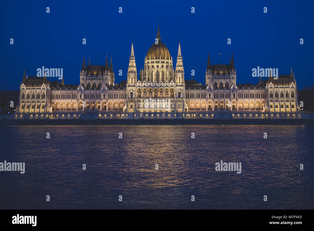 Escena nocturna del edificio del parlamento húngaro en el banco del río Danubio, visto desde el lado de Buda. Foto de stock
