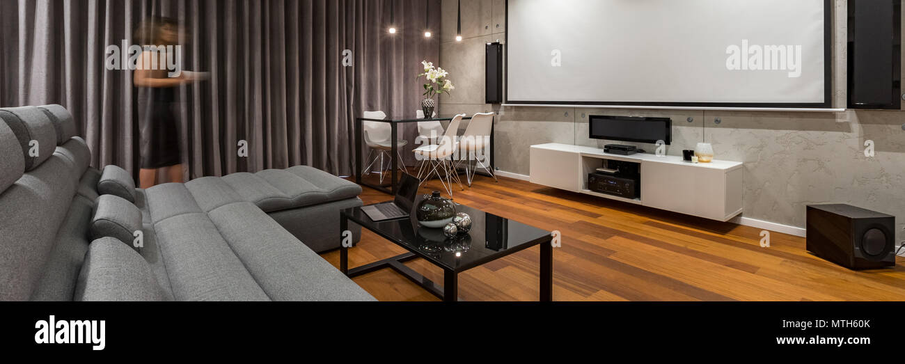 Salón con proyector pantalla gris, sofá y mesa de café negro, panorama  Fotografía de stock - Alamy