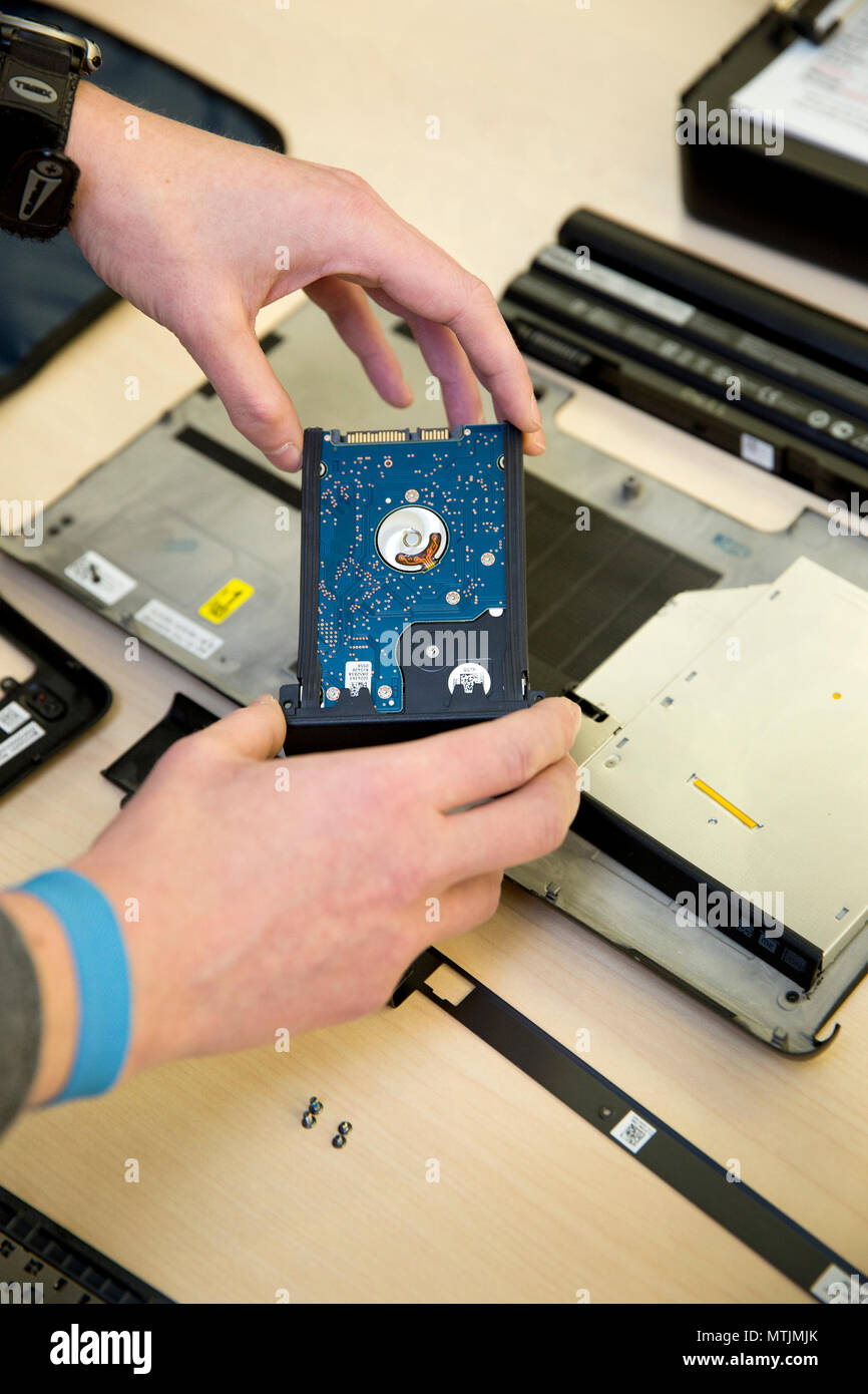 Un técnico mantiene una unidad de disco duro portátil Foto de stock