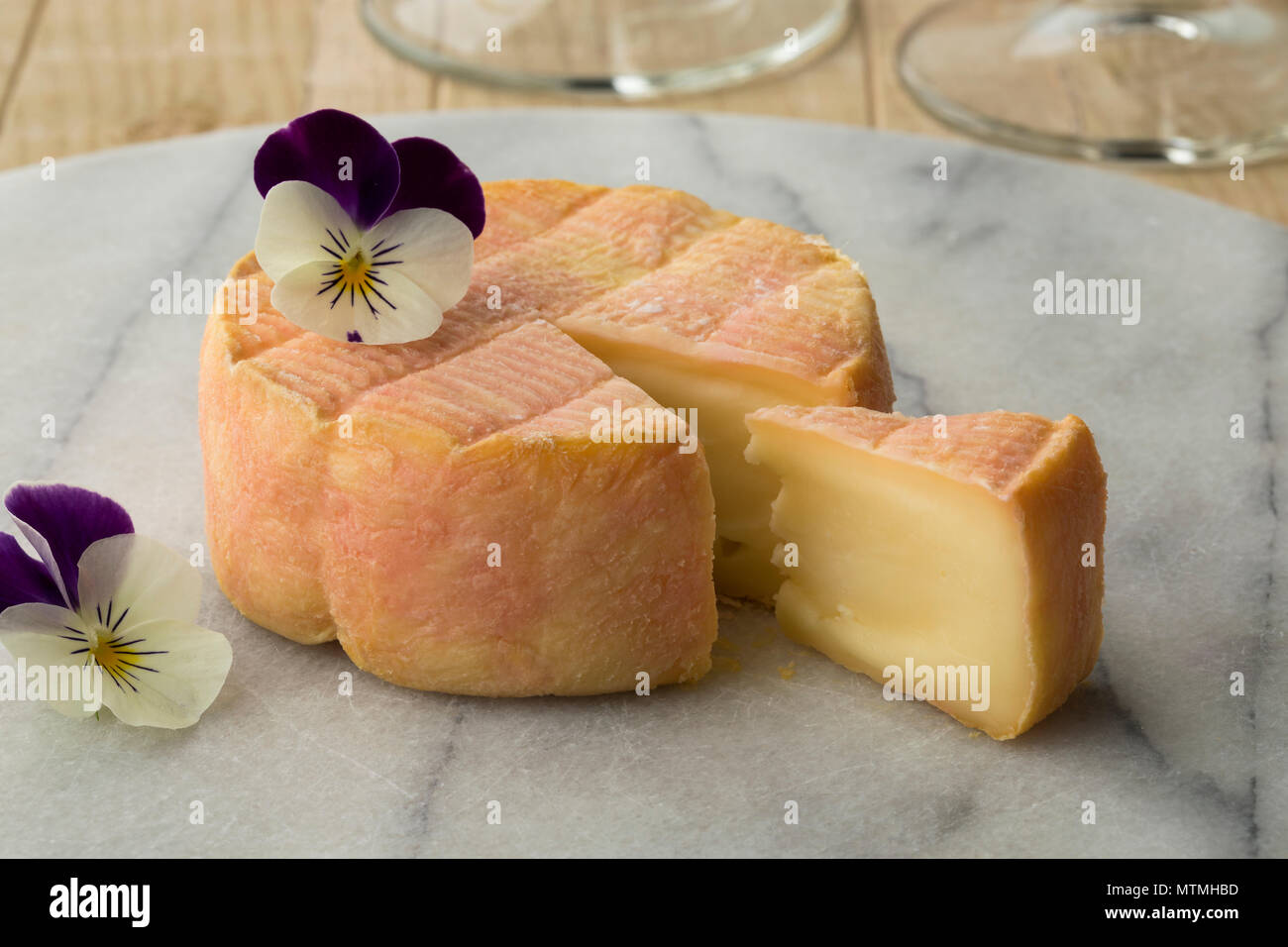 Francés Marc de Mascate queso sobre una tabla de quesos decorado con viola Foto de stock