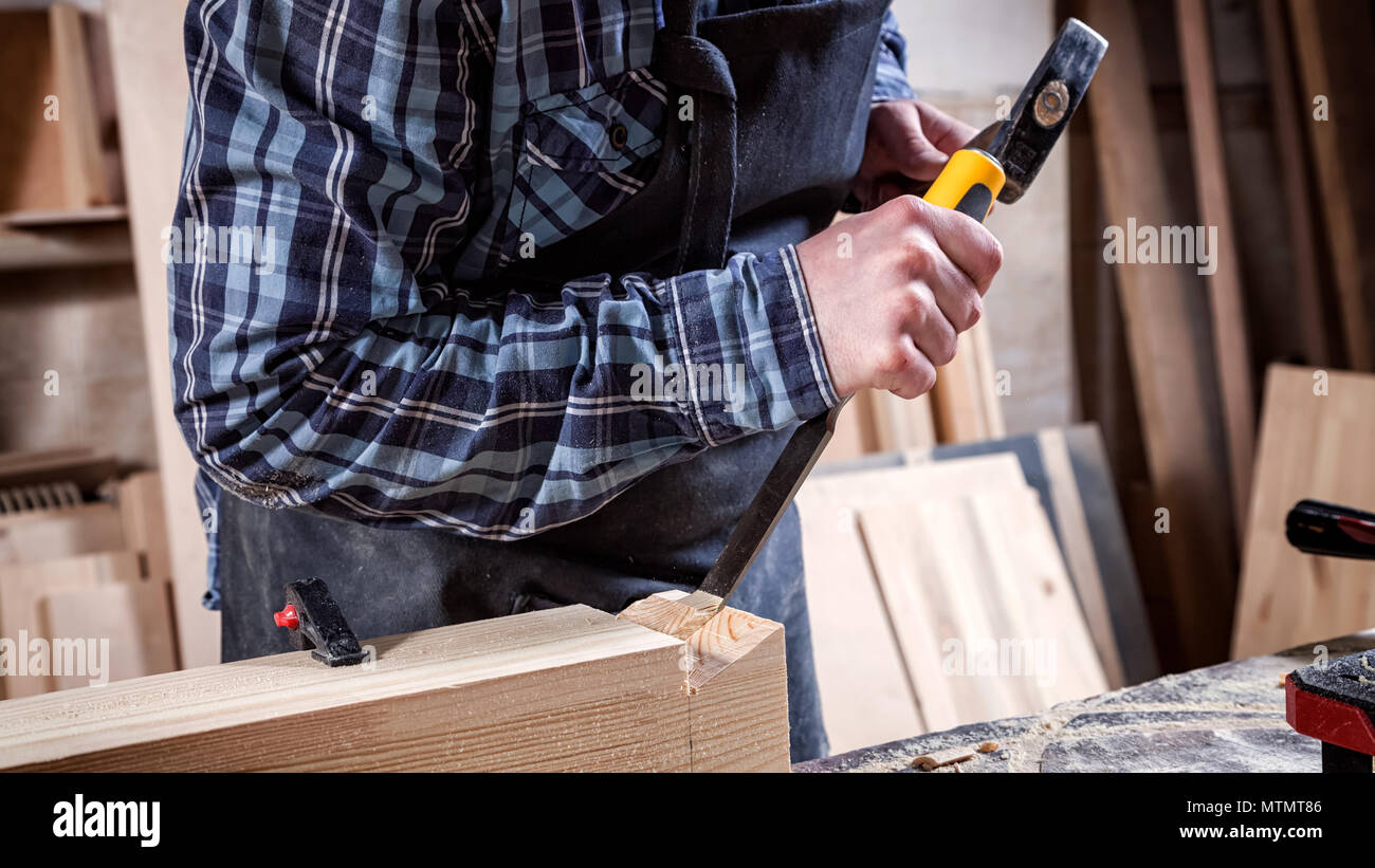 Fuerte en ropa de trabajo carpintero tallar madera usando una herramienta  para madera, cincel, las manos cerca de carpintería y artesanía concepto  Fotografía de stock - Alamy