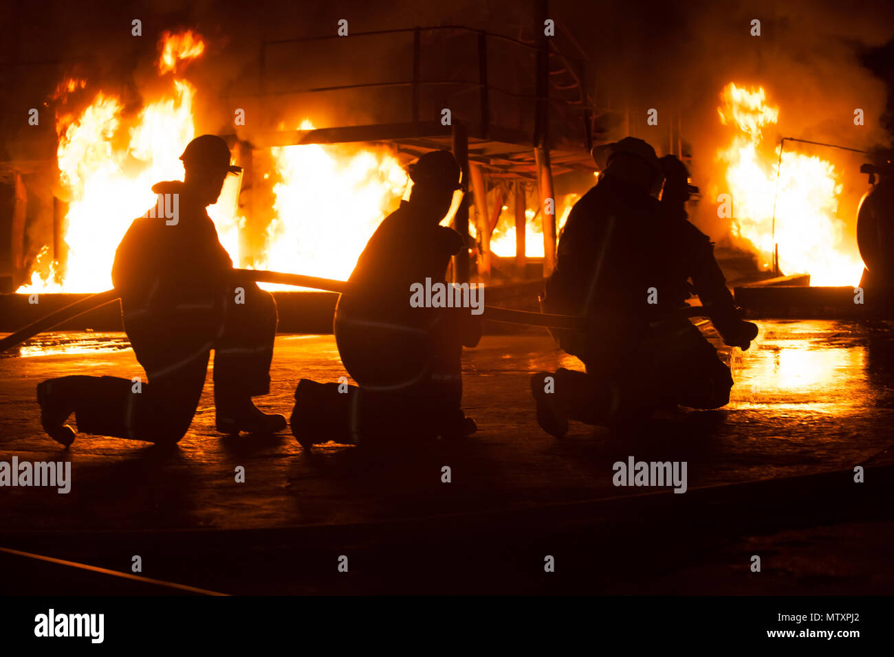 Johannesburgo, Sudáfrica: Mayo, 2018 Bomberos de rodillas durante ejercicios de entrenamiento de extinción de incendios Foto de stock