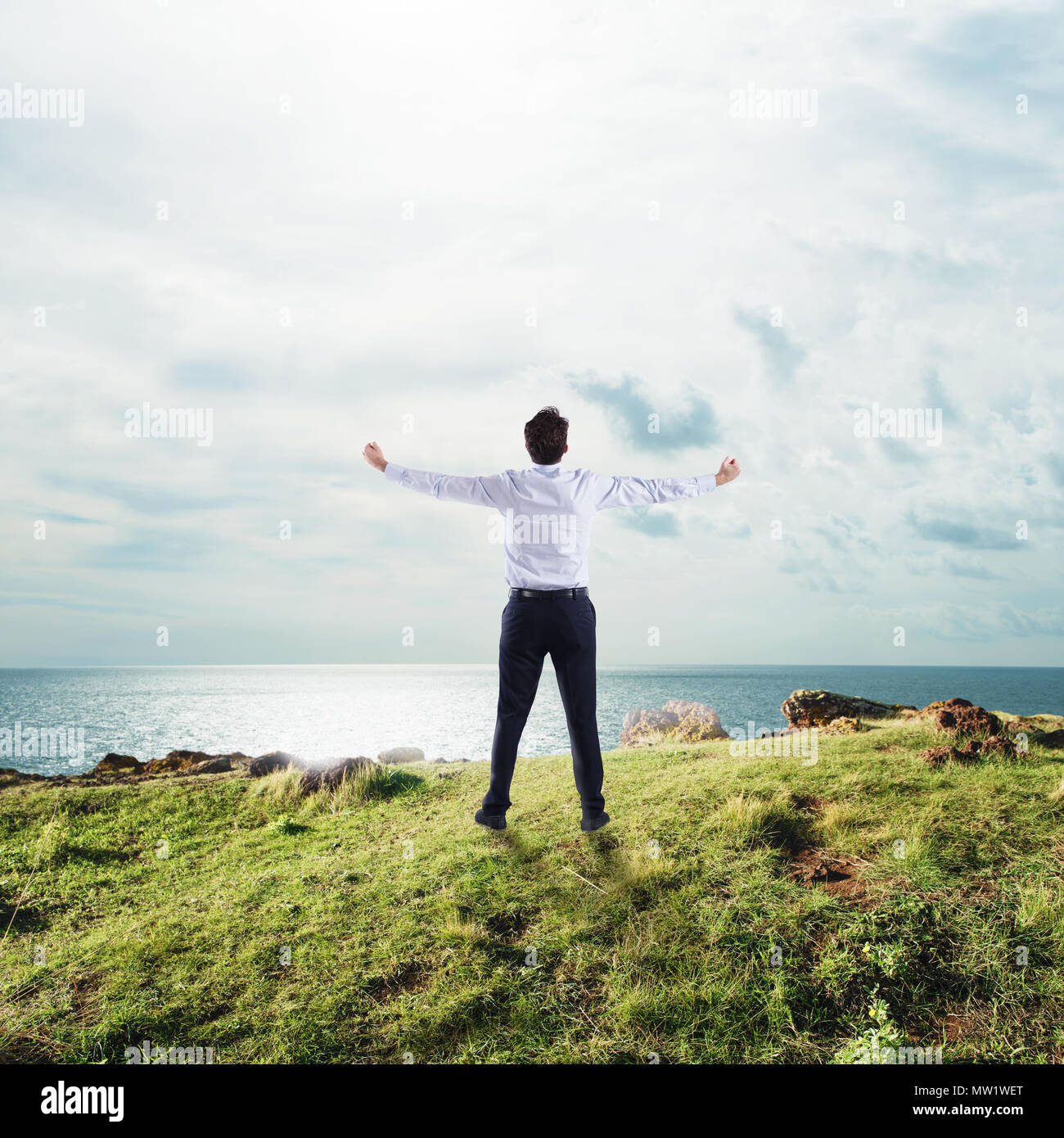 Empresario con los brazos abiertos hacia el cielo. Concepto de éxito y libertad Foto de stock