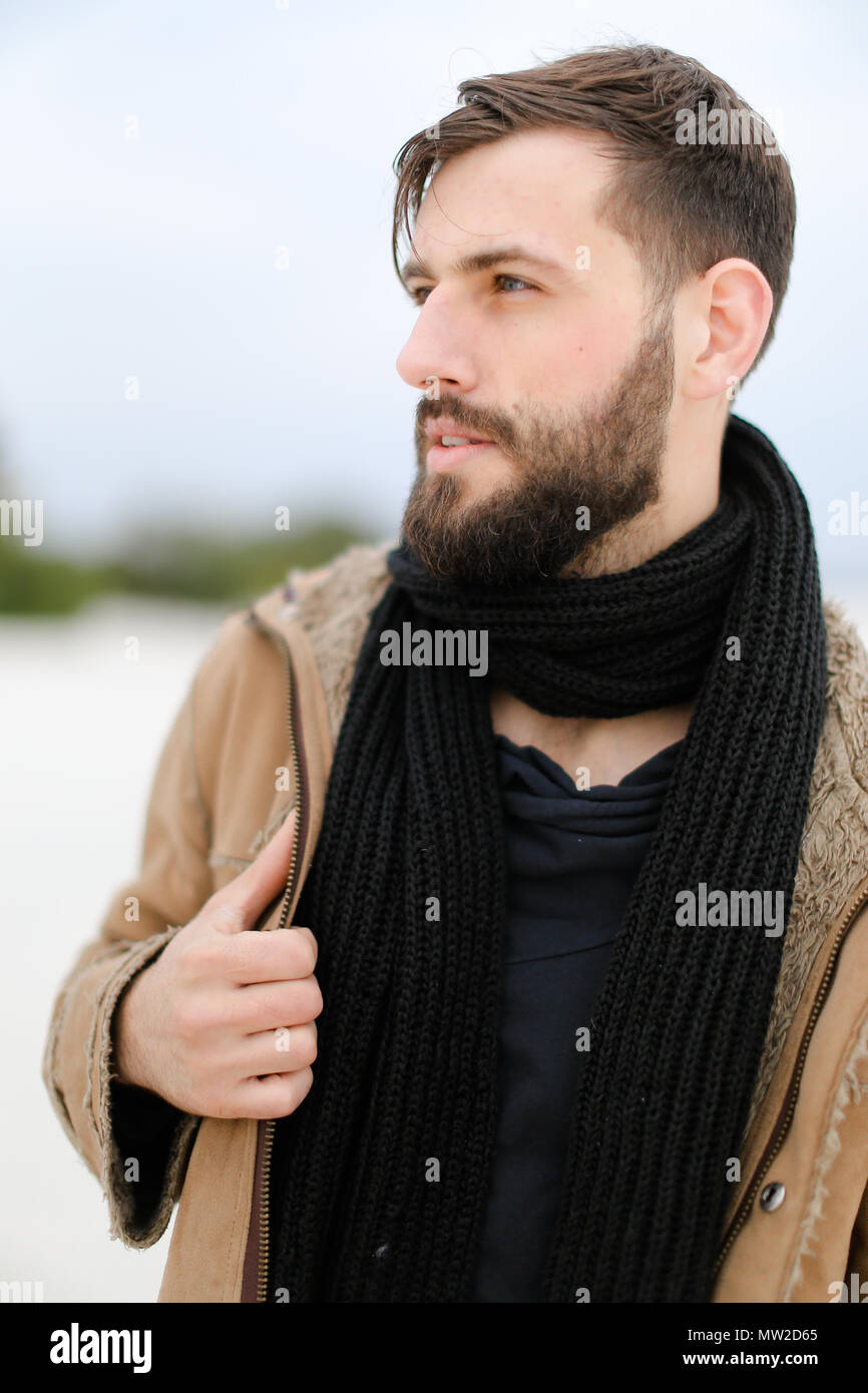 Tormento Pera Humanista Cerrar retrato del hombre caucásico joven con barba llevar abrigo y bufanda  negra en blanco permanente de fondo en invierno Fotografía de stock - Alamy