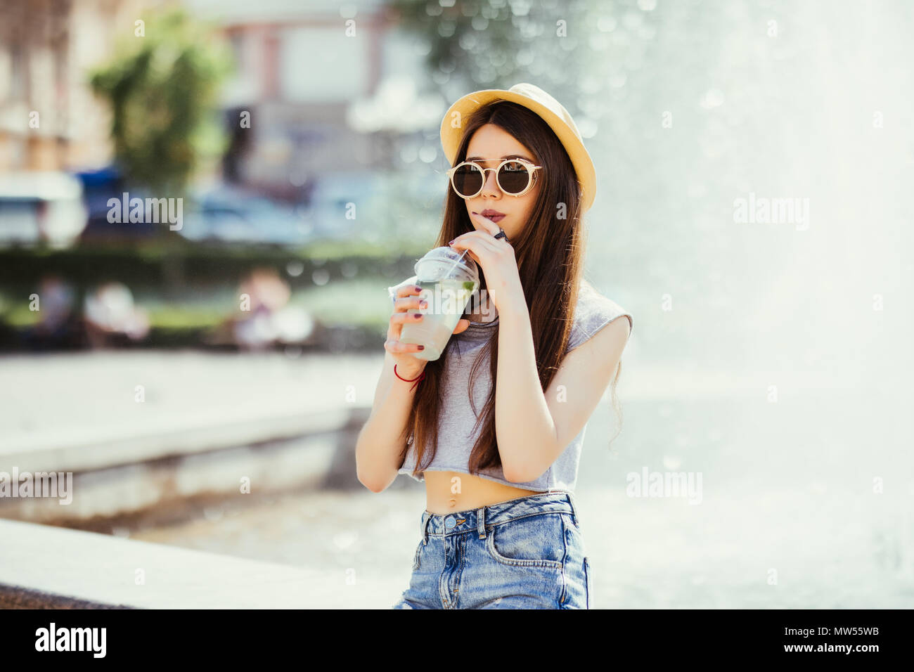 El verano soleado estilo de moda retrato de joven con estilo HIPSTER mujer caminando por la calle, vistiendo ropa de moda cute, bebiendo deliciosos batidos, SMI Fotografía de stock - Alamy