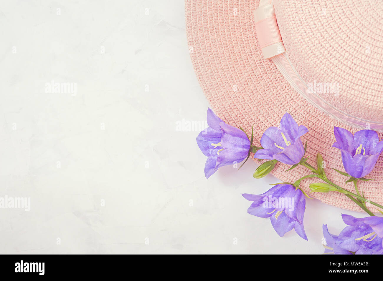 Sombrero de Paja con hermosas flores ramo de flores de color lila . Antecedentes, flatlay pastel. Foto de stock