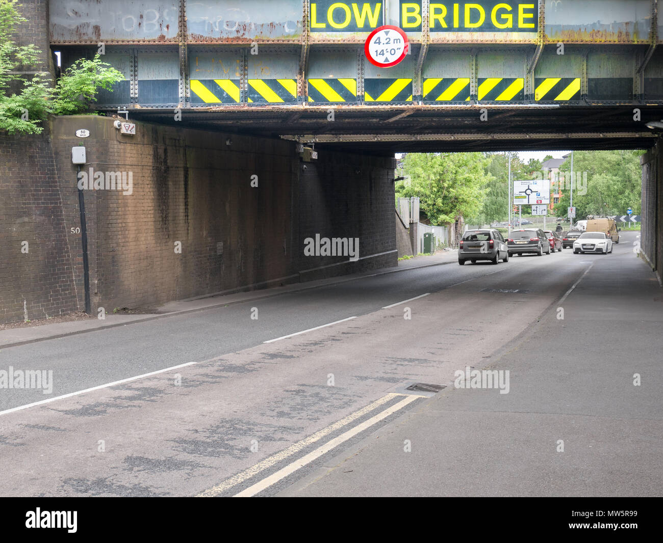 Advertencia a los conductores de vehículos altos sobre un puente ferroviario bajo 4,2 m (14 ft) o en la A4300 Rothwell Road, cerca del centro de la ciudad de Kettering, Inglaterra. Foto de stock