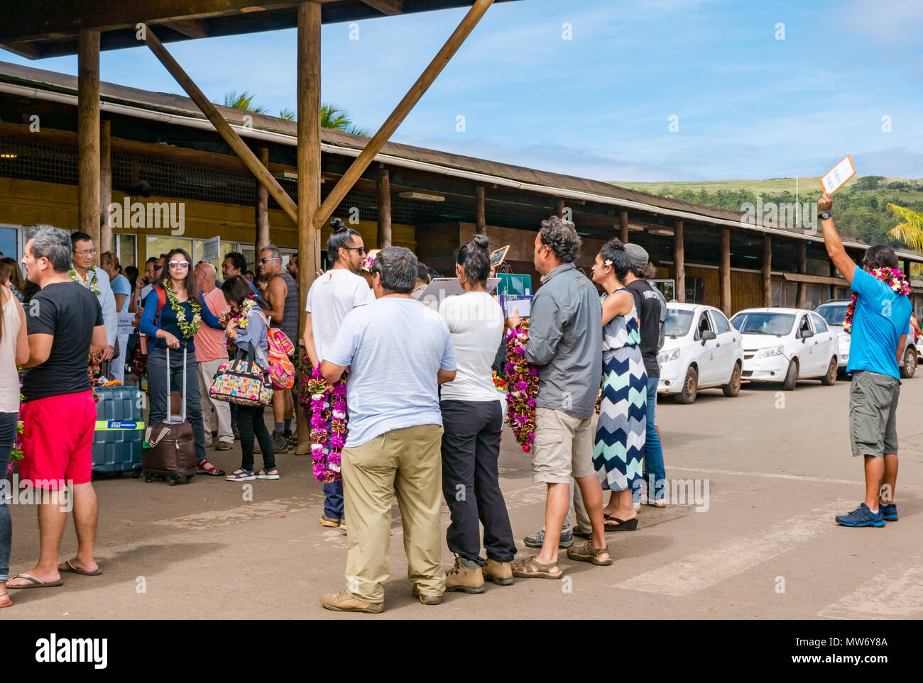 Llegadas al aeropuerto Internacional Mataveri, Isla de Pascua, Chile, con turistas ser saludado por tour operadores acogiéndolos con guirnaldas lei Foto de stock