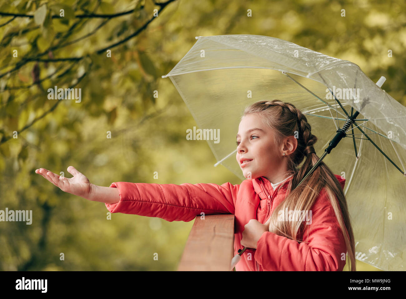 Cute little niño sosteniendo paraguas en otoño park Foto de stock