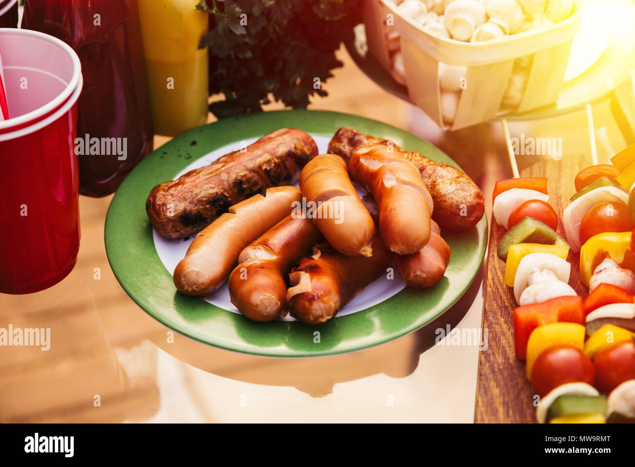 Salchichas cocidas en la parrilla al aire libre servido en la placa Foto de stock