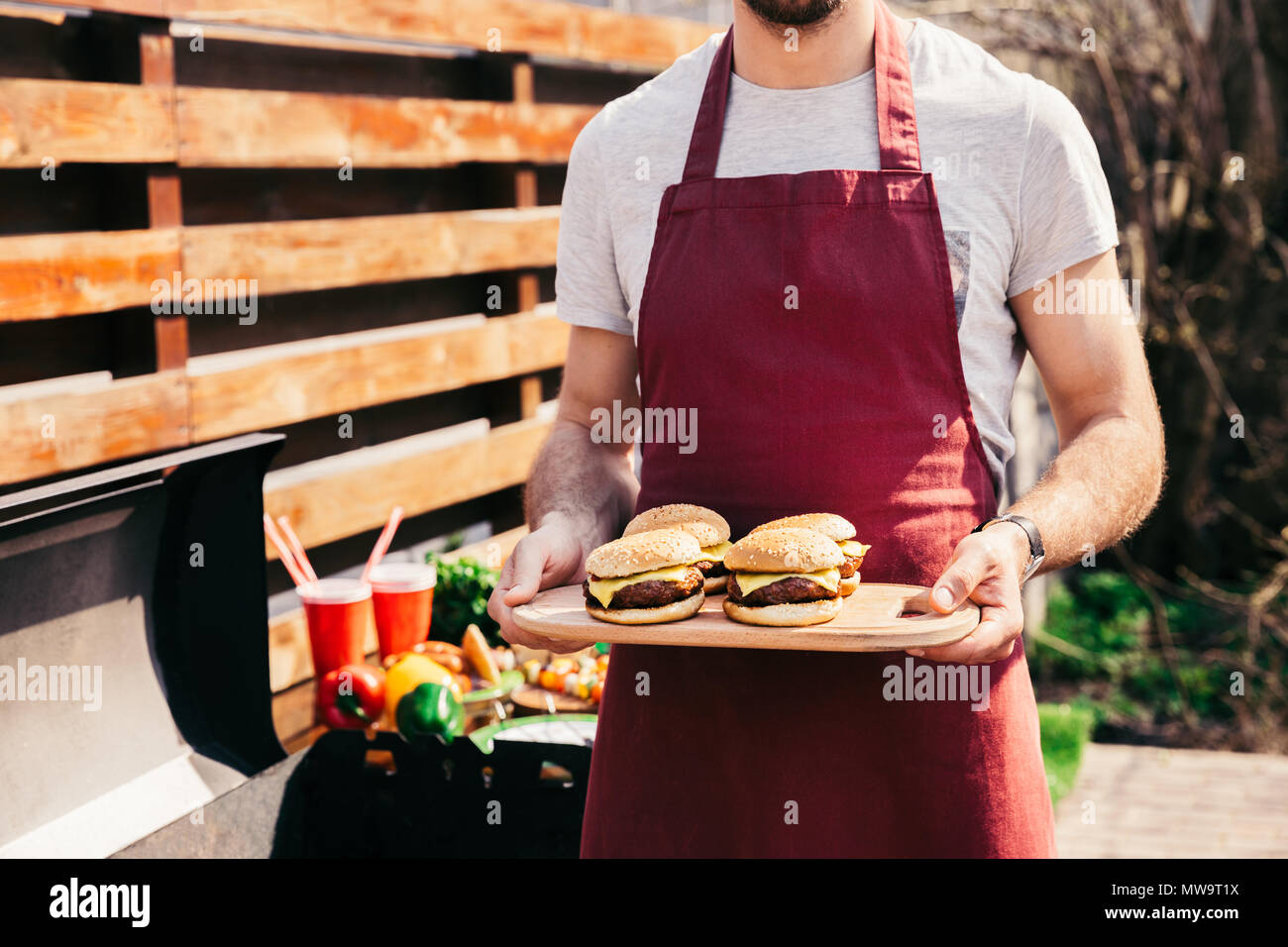 Chef celebración junta con hamburguesas a la parrilla para barbacoas al aire libre Foto de stock