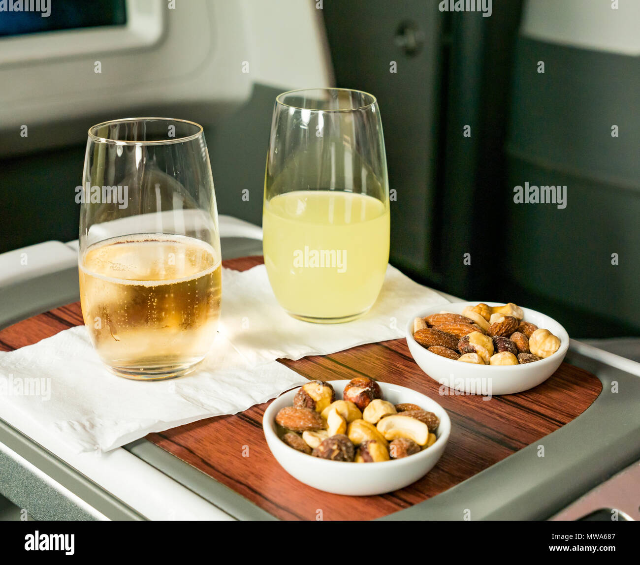 Los asientos de clase Business LATAM Airlines Boeing 787 Dreamliner 787 volando desde la Isla de Pascua a Santiago; pisco sour y vino espumoso bebidas de bienvenida con mezcla de frutos secos Foto de stock