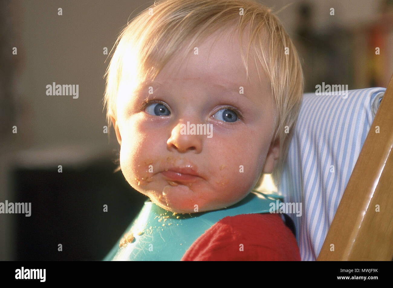 Desordenado de 9 meses Baby Boy con alimentos alrededor de su boca Foto de stock