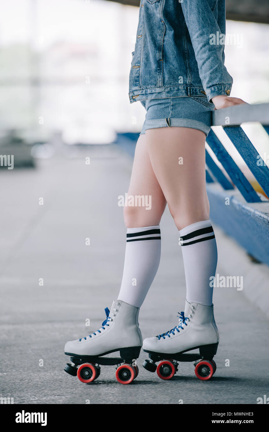 Close-up de una niña de la piernas vistiendo patines y calcetines