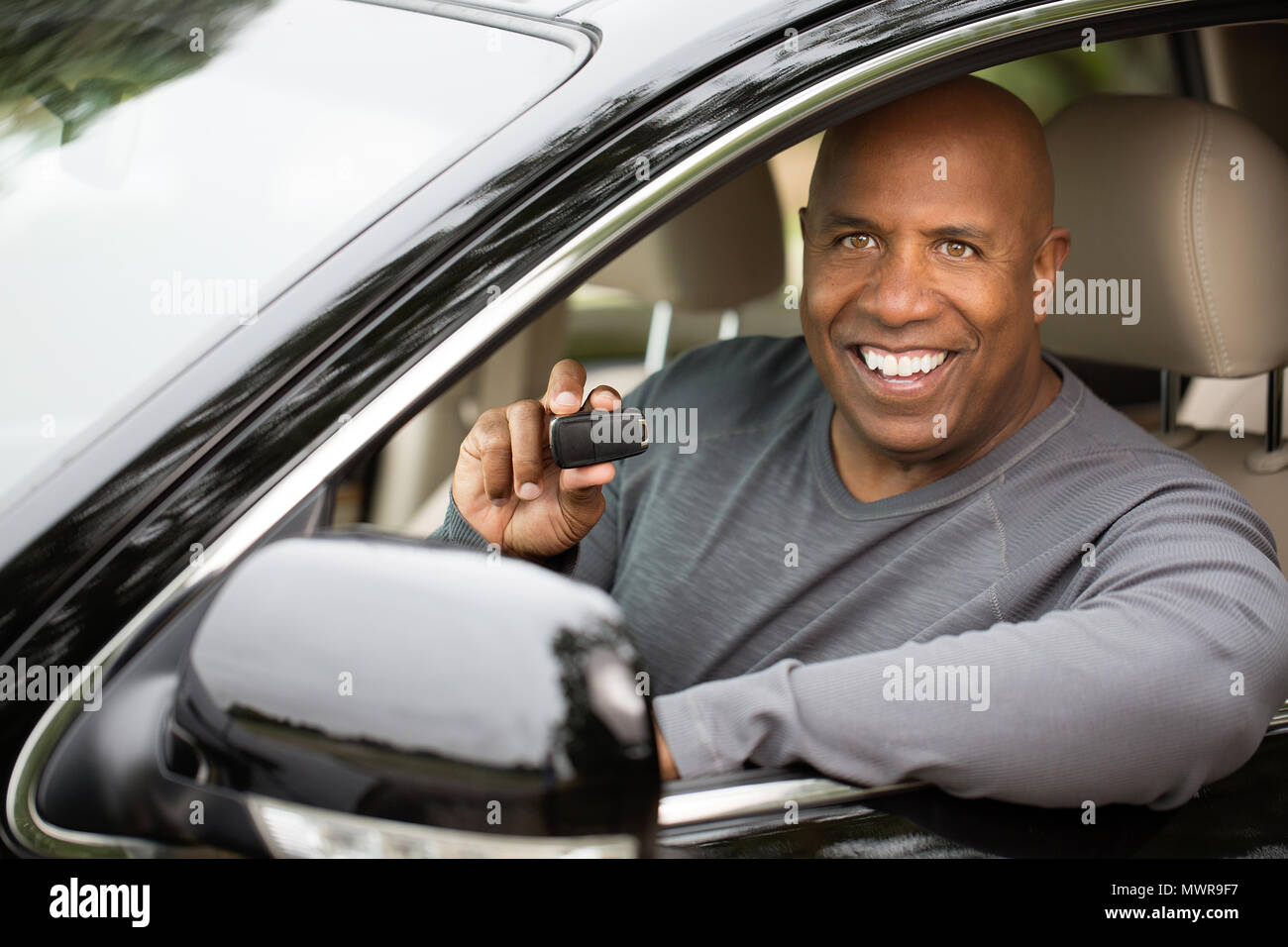 Hombre afroamericano conduciendo un coche nuevo Foto de stock