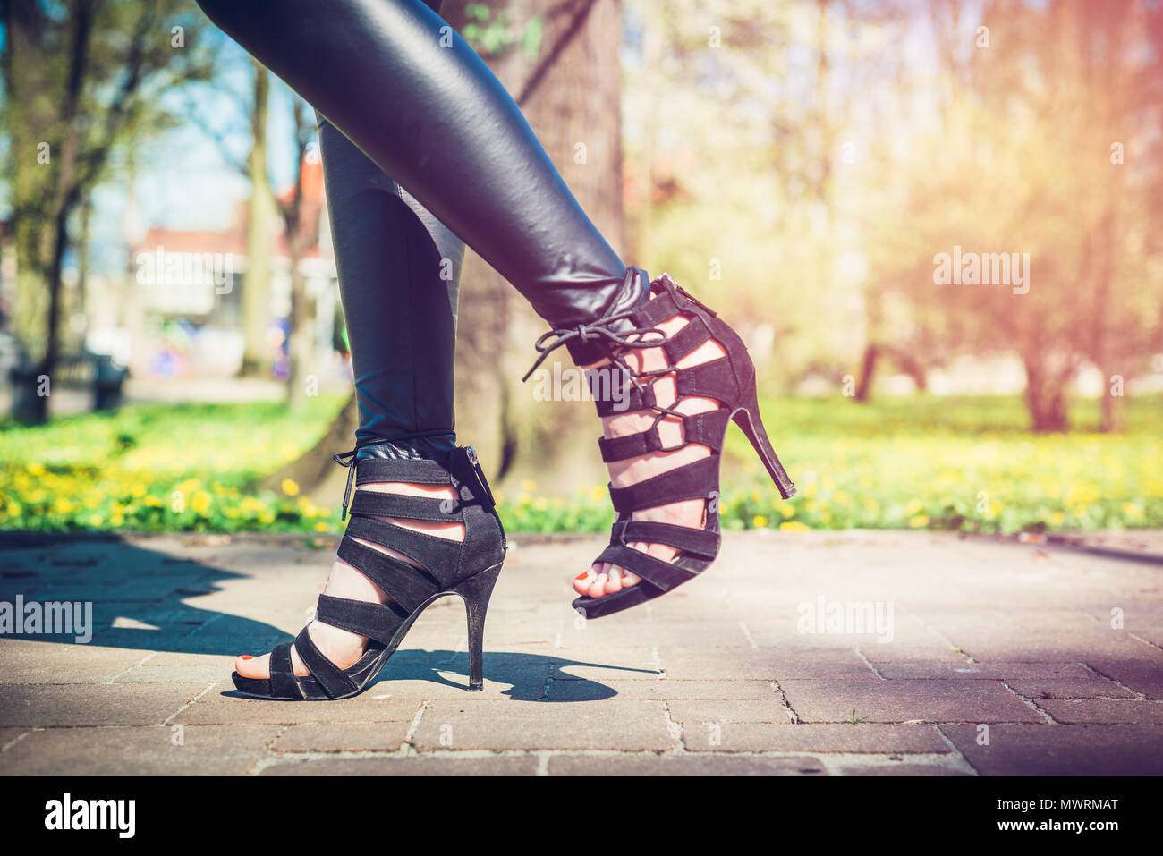 Ver las piernas de una mujer caminando con flores. La chica en pantalones  negros se mueve alrededor del parque fuera. Beuty y concepto de moda  Fotografía de stock - Alamy