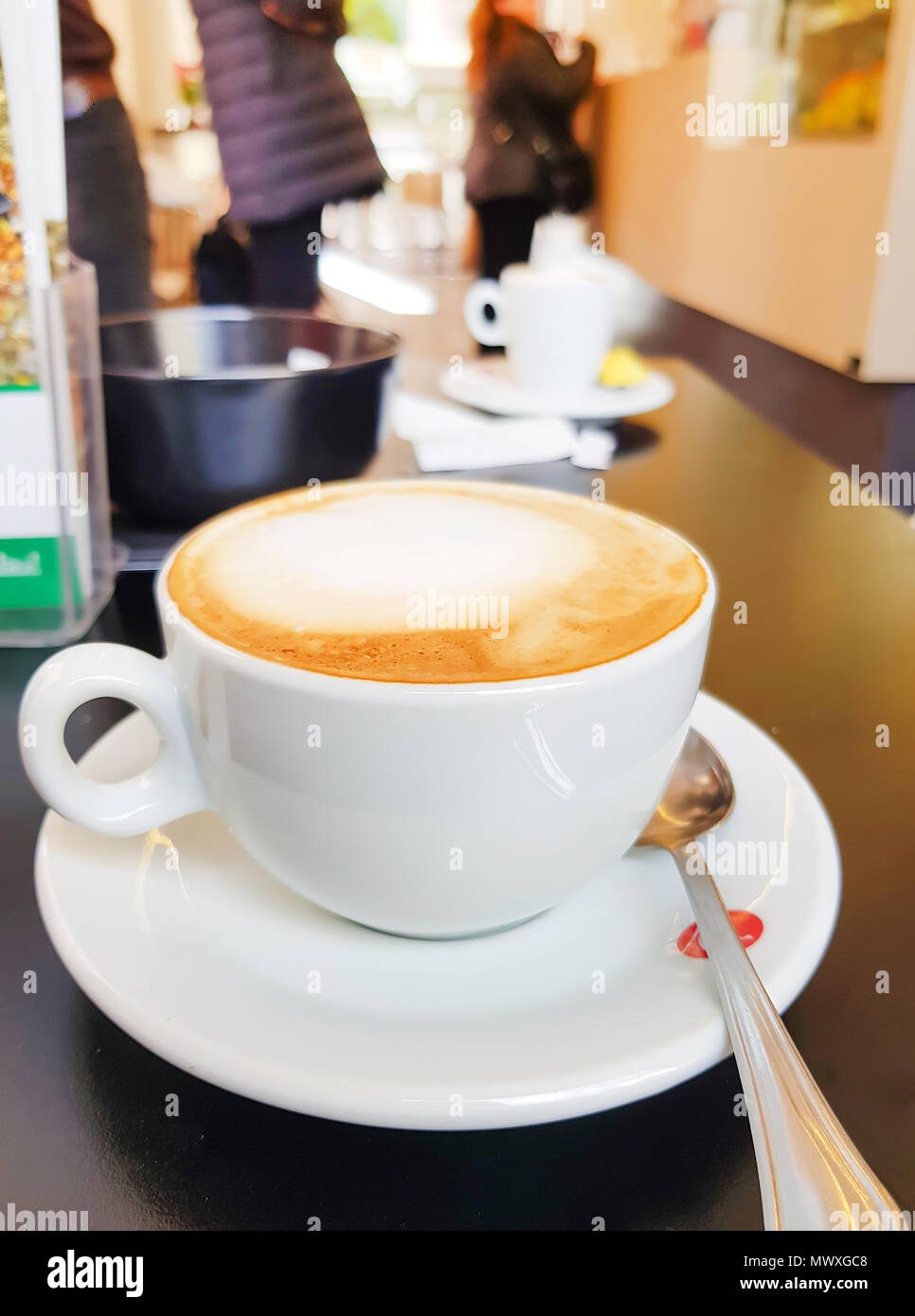 Taza de leche caliente o una taza de capuchino en la mesa de café en el bar  o cafetería estilo europeo Fotografía de stock - Alamy