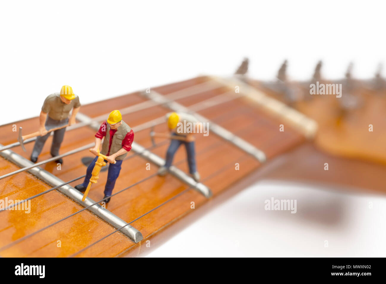 Los trabajadores en miniatura la fijación de los trastes de una guitarra Foto de stock