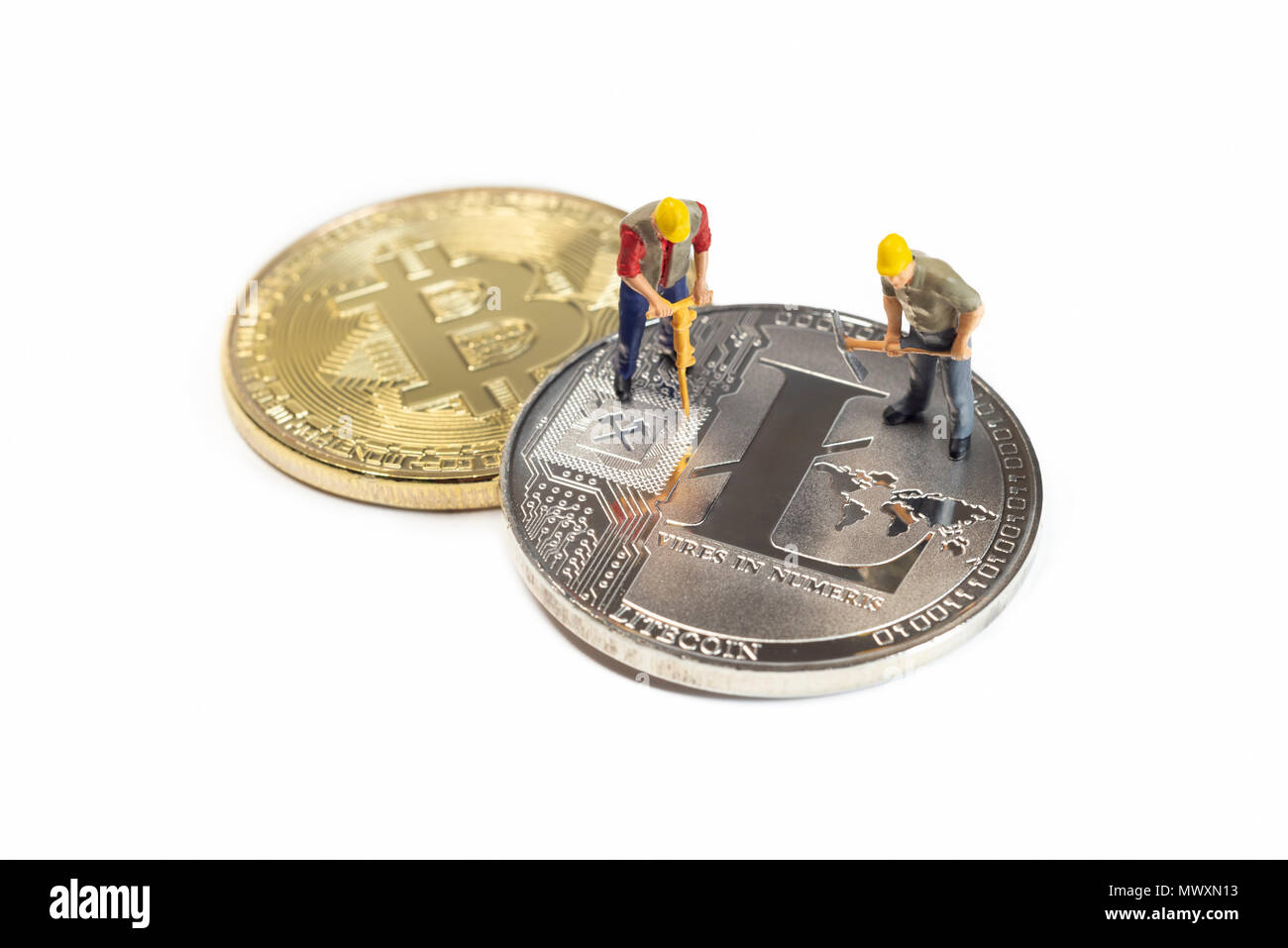 Los trabajadores mineros en miniatura Litecoin sobre una superficie blanca Foto de stock
