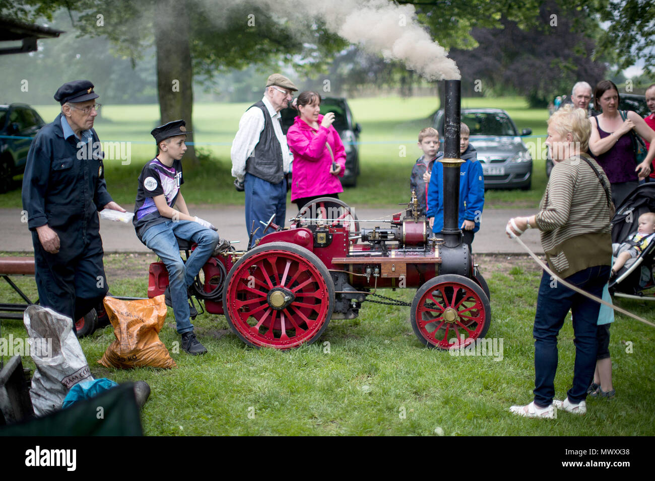 Un joven se asienta sobre una locomotora de vapor, hechos a mano en la feria vintage Himley Hall en Dudley, West Midlands. Foto de stock