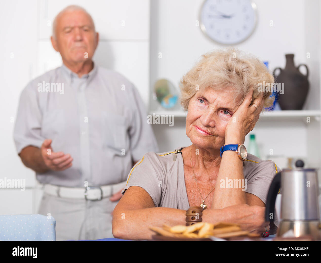 Ancianos malestar mujer sentada por separado teniendo problemas en la relación con su esposo Foto de stock