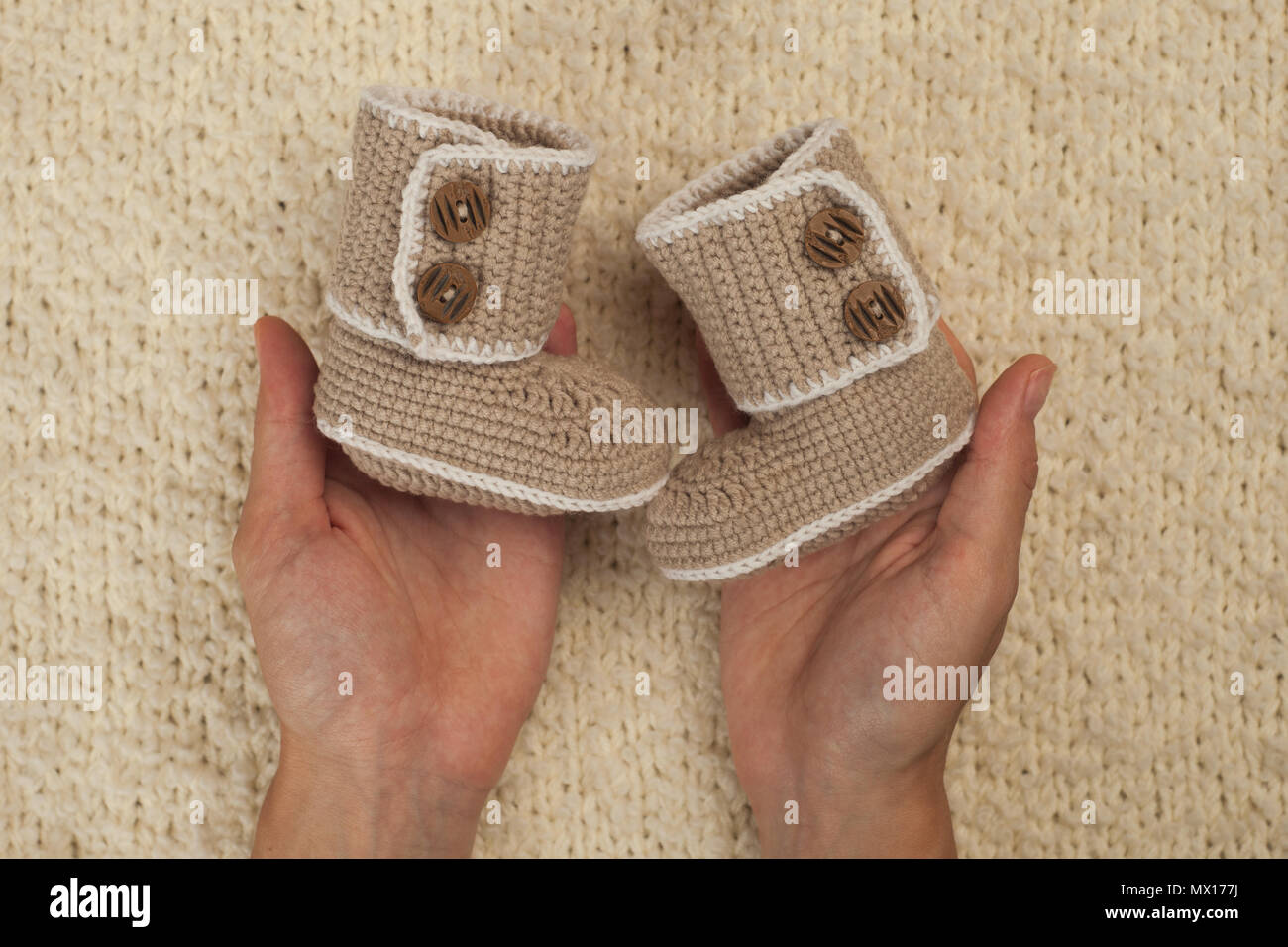 Patucos para recién nacido en manos de la madre, la niña embarazada con  mano knetted baby shoes esperando bebé. embarazo concepto. Los botines del  recién nacido Fotografía de stock - Alamy