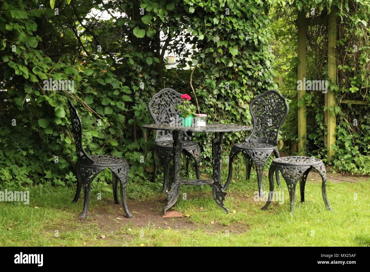 Hierro forjado, mesa y sillas de jardín Foto de stock