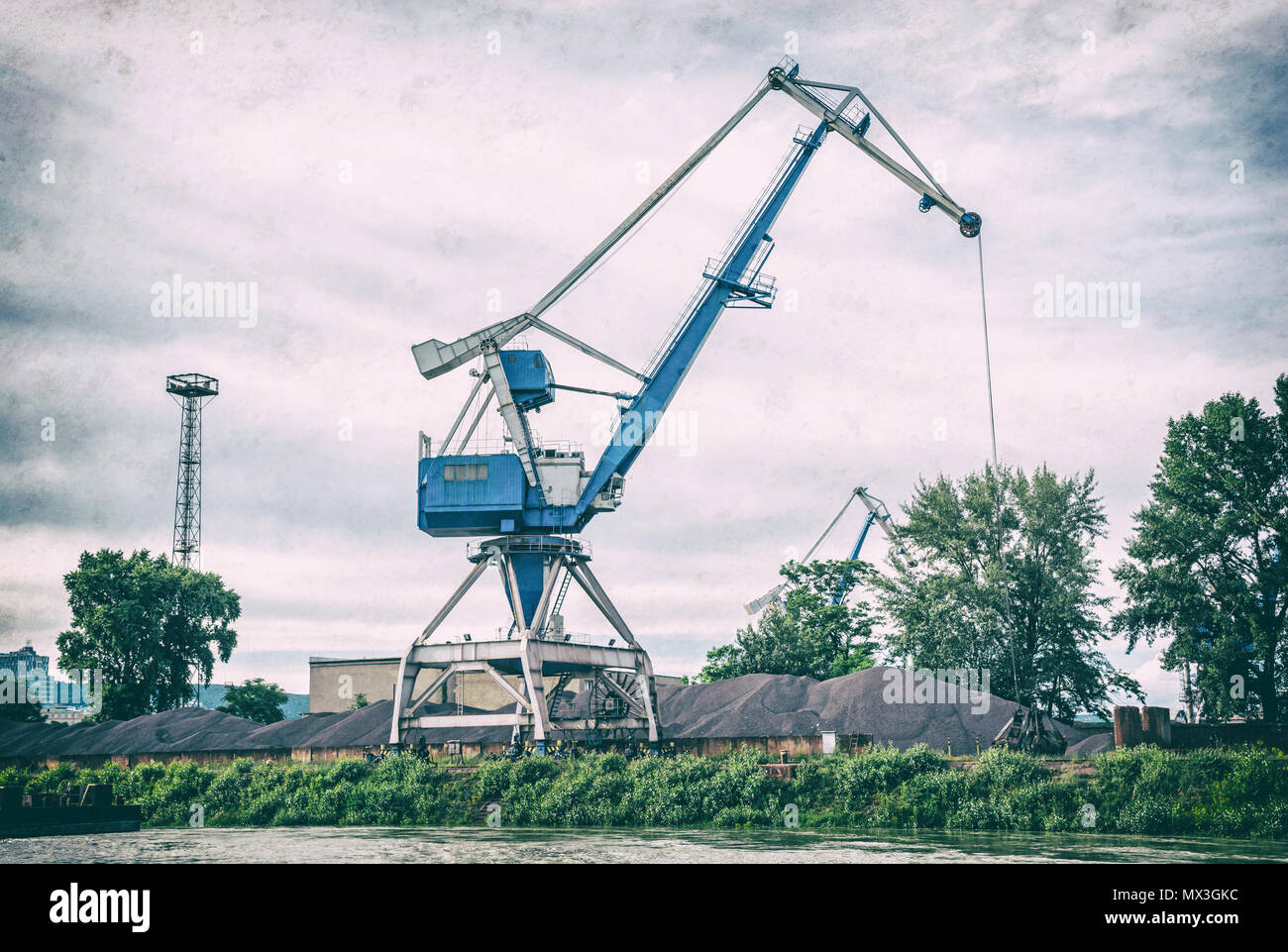 Blue Crane en el puerto de carga de traducir el carbón. Escena industrial. Filtro de fotografía analógica con arañazos. Foto de stock