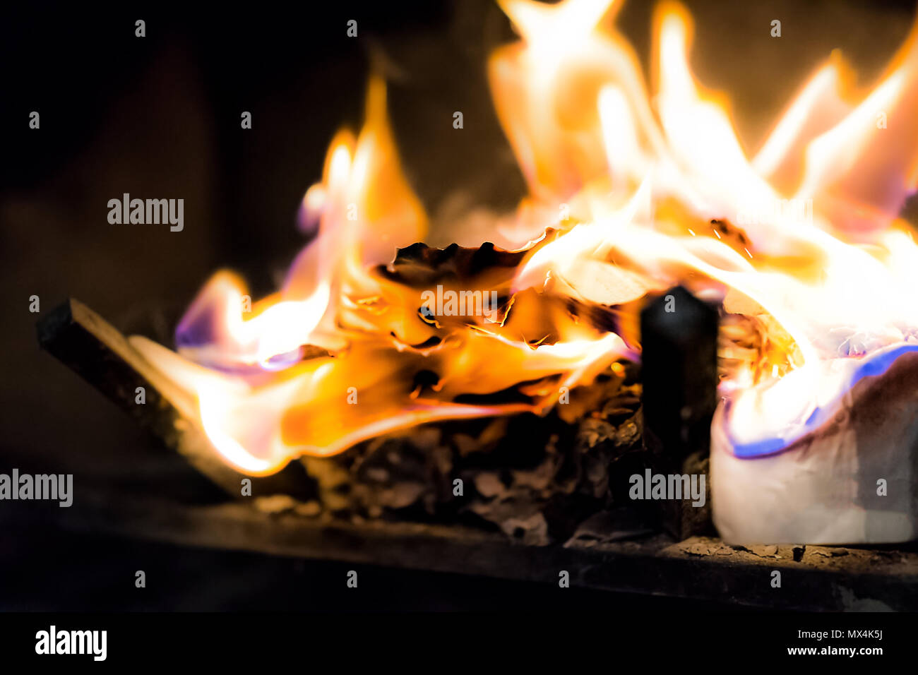 Quema el papel, letras en interiores chimenea interior con detalle el  acercamiento de Orange, la llama azul Fotografía de stock - Alamy