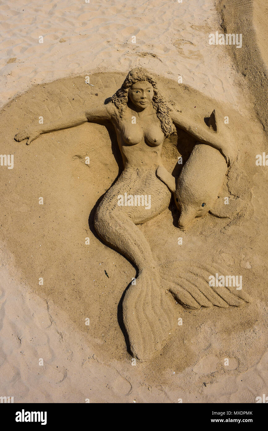 Escultura de arena en Guardamar del Segura en la playa del mar Mediterráneo. Mermaid con los delfines. Espacio para copiar Foto de stock