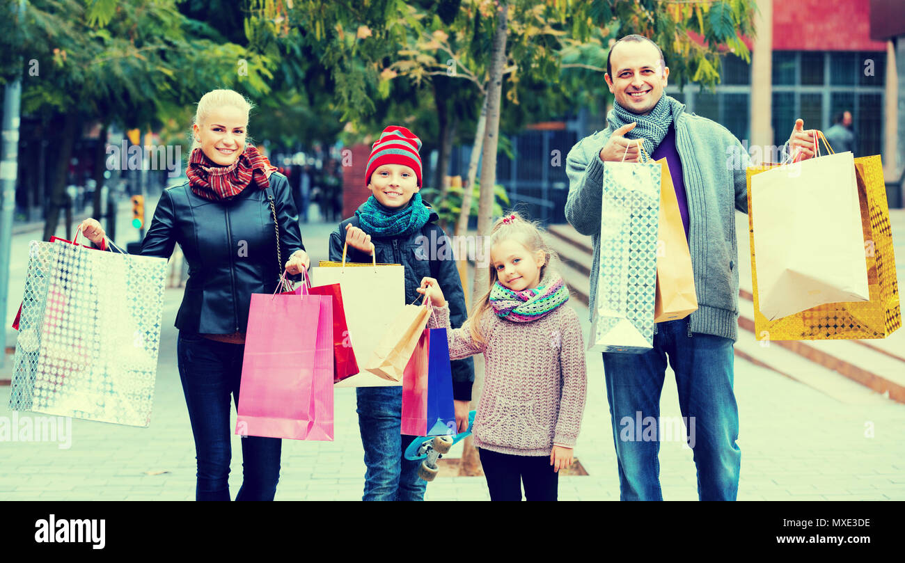 Unión pareja con niños y bolsas de compras en las calles de la ciudad Foto de stock