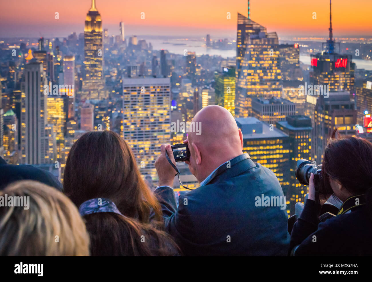 Los turistas fotografiar el paisaje de Manhattan al atardecer en la Ciudad de Nueva York Foto de stock