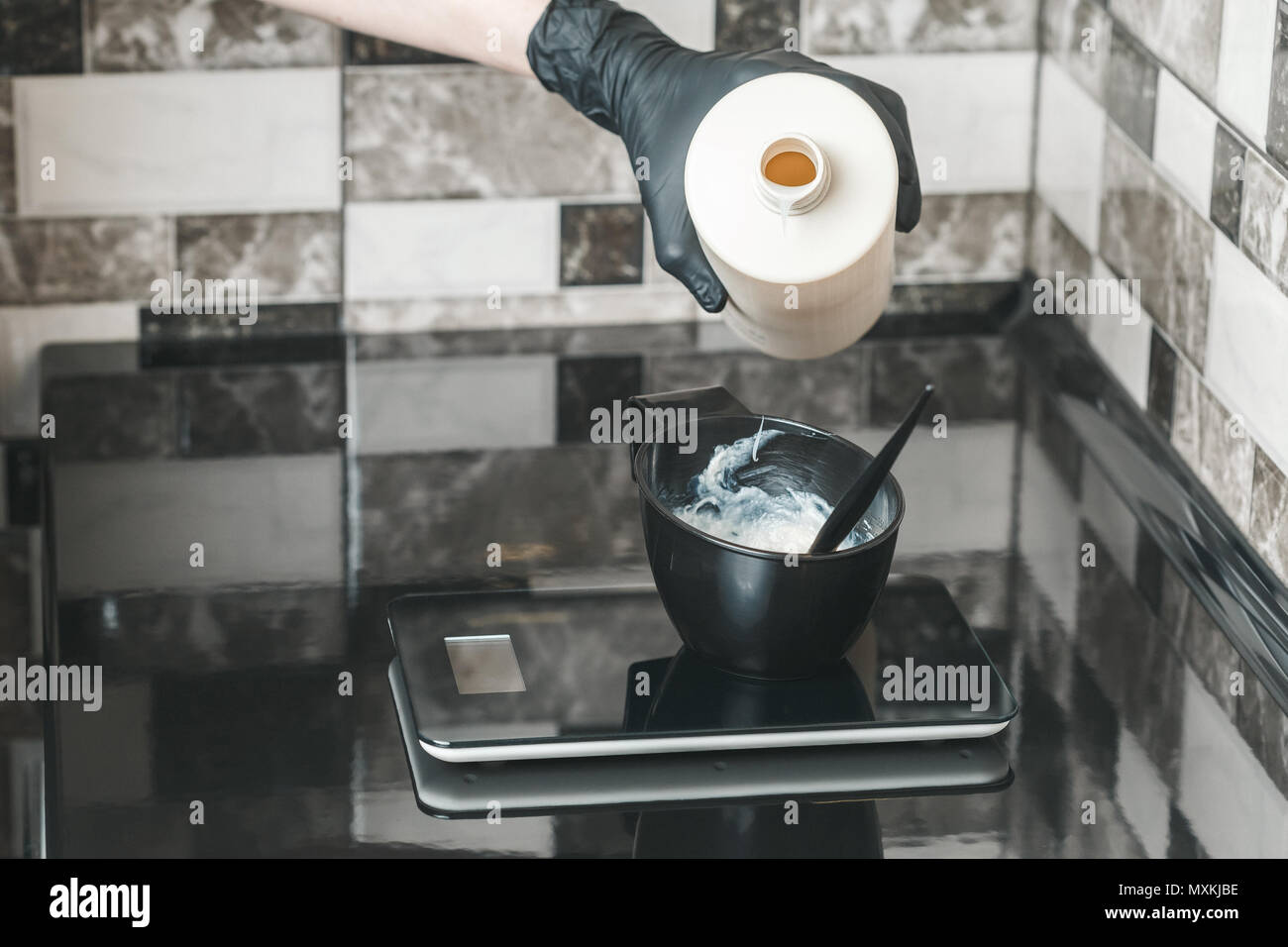 Peluquero vertiendo un oxidante crema en el recipiente la preparación de un  tinte para colorear Fotografía de stock - Alamy