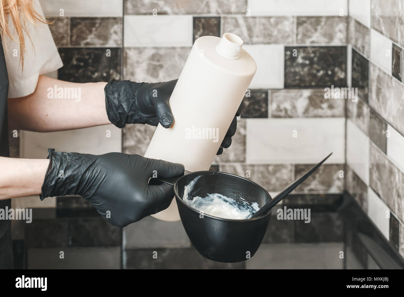 Peluquero vertiendo un oxidante crema en el recipiente la preparación de un  tinte para colorear Fotografía de stock - Alamy
