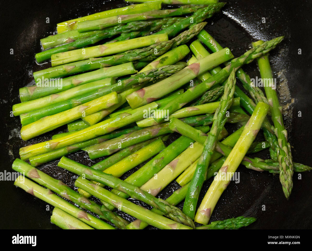Los espárragos verdes cocinar en una sartén con mantequilla Fotografía de  stock - Alamy
