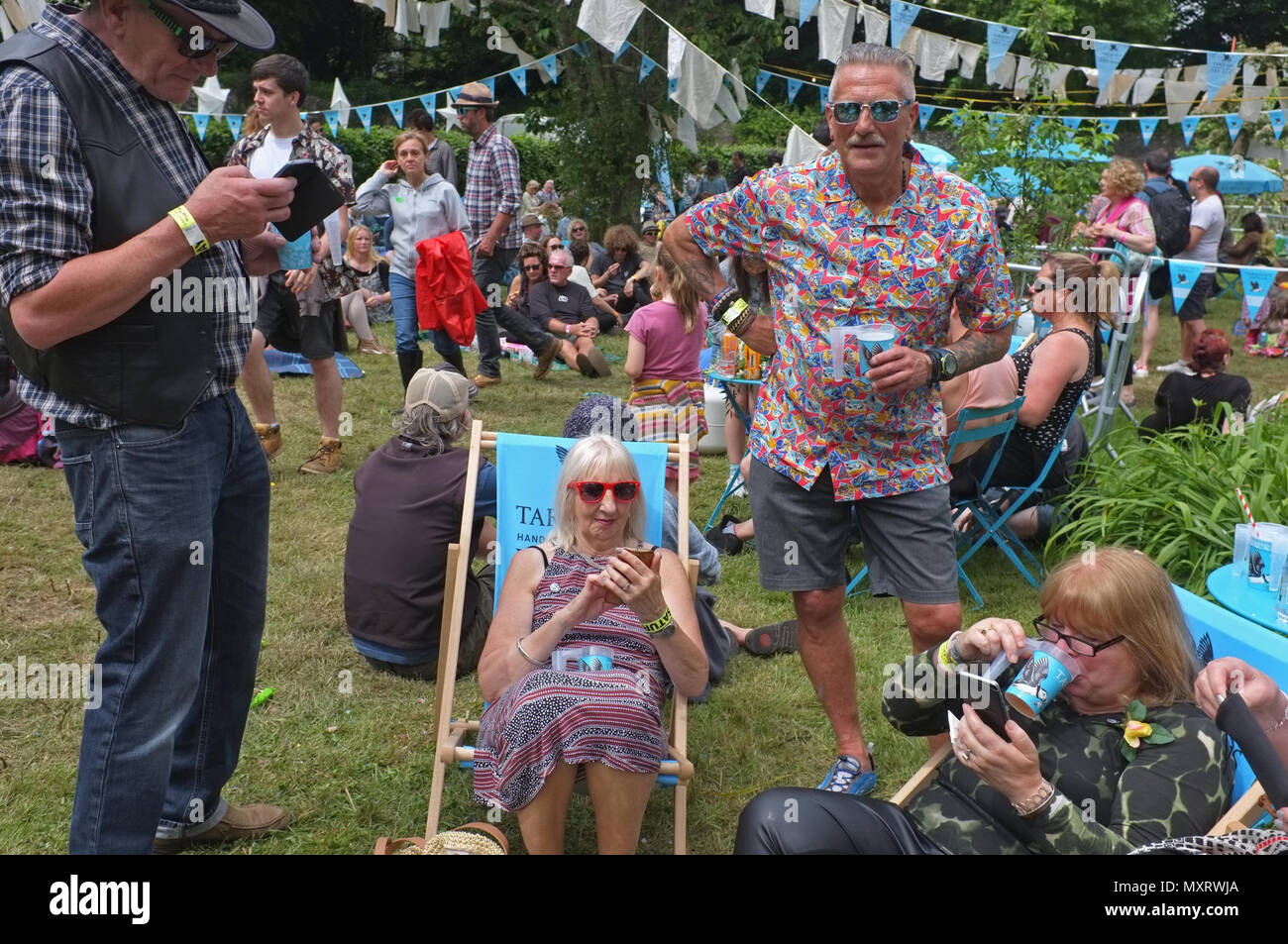 Un grupo de personas de edad en sus teléfonos en un festival Foto de stock