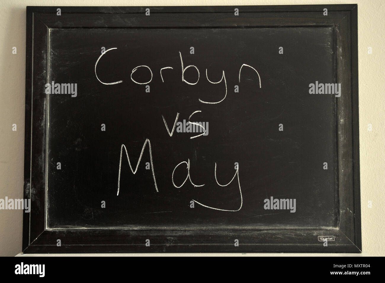 Corbyn vs mayo escrito en blanco tiza en una pizarra. Foto de stock