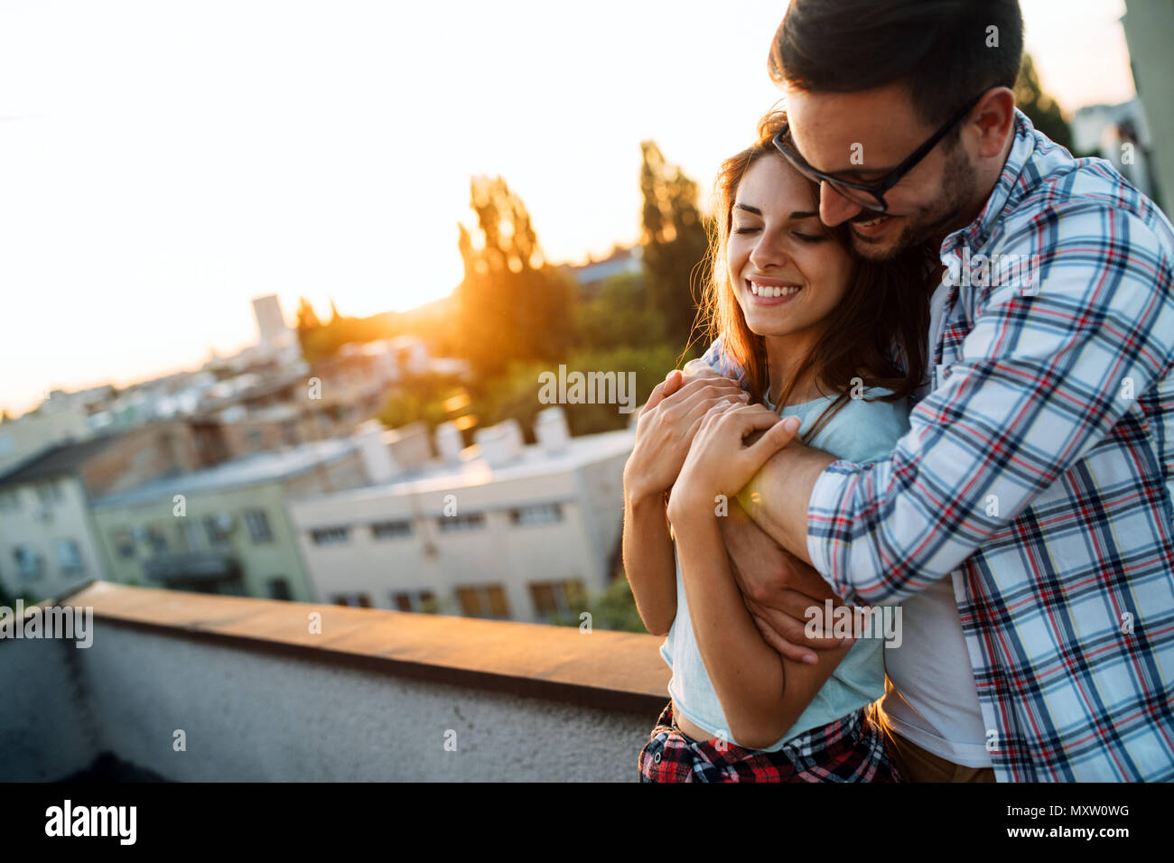 Retrato de una joven mujer amorosa abrazando desde atrás Foto de stock