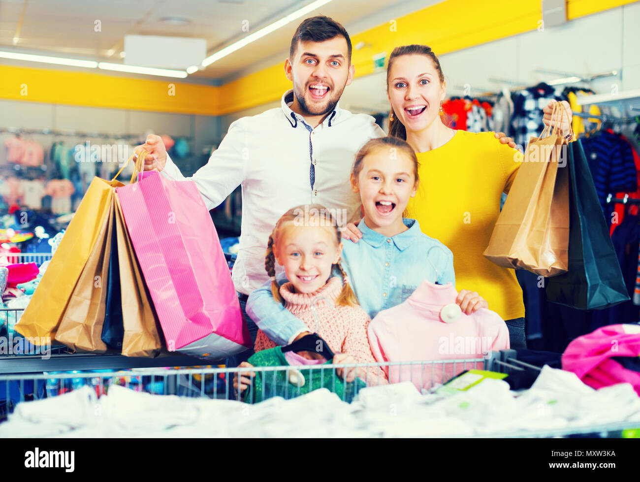 Muy sonriente y amable joven familia de cuatro, con bolsas de compras en la  tienda de ropa Fotografía de stock - Alamy