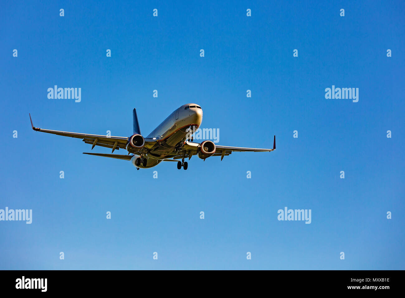 Gran avión de pasajeros volando en el cielo azul Foto de stock