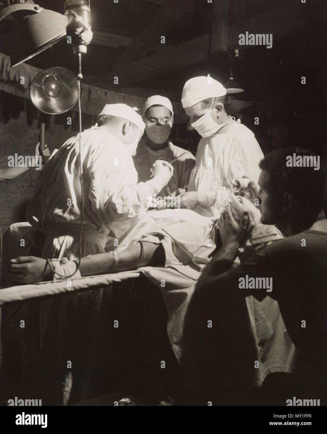 Los médicos quitar shcrapnel desde el abdomen de un leatherneck unos mil metros de primera línea de Iwo Jima. Ayudante médico administra éter Evac Marina 4ª Div. Foto de stock