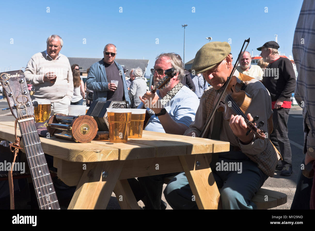 músicos del DH Folk Festival STROMNESS ORKNEY Músico escocés tocando instrumentos al aire libre violín música de guitarra pub al aire libre escocia Foto de stock