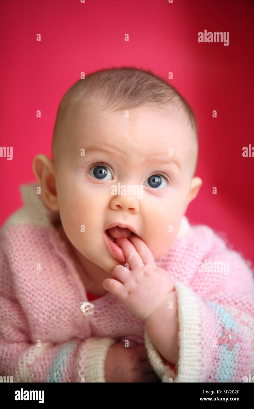 Un Lindo Bebe De Grandes Ojos Curiosos Jovenes Vestidos De Rosa Sobre Fondo De Color Rosa Cerise 0 A 6 De 6 A 12 Meses De Edad Fotografia De Stock Alamy